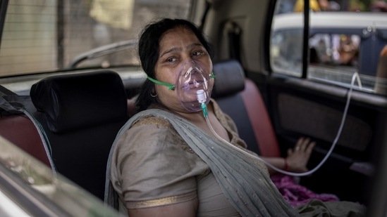 A Covid-19 patient sits inside a car and breathes with the help of oxygen provided by a Gurdwara, a Sikh house of worship, in New Delhi on April 24. Hospitals in and around the capital said oxygen remained scarce, despite commitments to step up supplies, Reuters reported.(Altaf Qadri / AP)