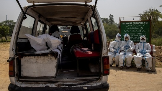 The body of a person, who died from the coronavirus disease (Covid-19), is seen inside an ambulance as healthcare workers wait for a grave to be prepared for its burial at a graveyard in New Delhi. Crematoria and funeral grounds have been backlogged for hours in recent weeks, stressed by the rising numbers of Covid-19 fatalities.(Danish Siddiqui / REUTERS)