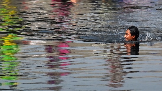 A boy cools himself as he swims in a canal amid rising temperatures in New Delhi. ( AFP) A boy cools himself as he swims in a canal amid rising temperatures in New Delhi. ( AFP)