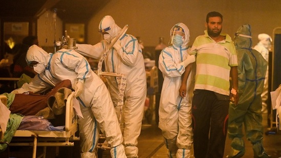 Health workers wearing personal protective equipment (PPE kit) attends to Covid-19 coronavirus positive patients inside a banquet hall temporarily converted into a covid care centre in New Delhi on April 28, 2021. (AFP) Health workers wearing personal protective equipment (PPE kit) attends to Covid-19 coronavirus positive patients inside a banquet hall temporarily converted into a covid care centre in New Delhi on April 28, 2021. (AFP)