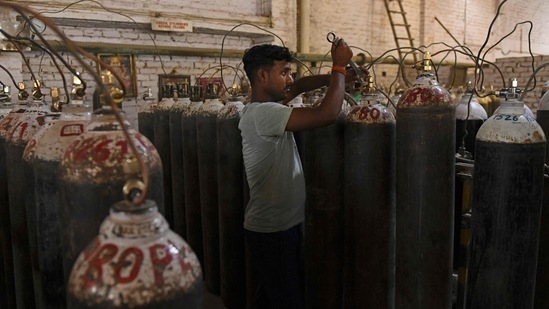 Workers are seen sorting oxygen cylinders that are being used for Covid-19 coronavirus patients before dispatching them to hospitals at a facility on the outskirts of Amritsar on April 28, 2021. (AFP) Workers are seen sorting oxygen cylinders that are being used for Covid-19 coronavirus patients before dispatching them to hospitals at a facility on the outskirts of Amritsar on April 28, 2021. (AFP)