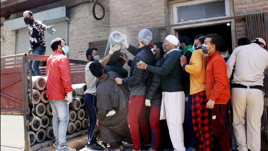 Attendants of Covid patients collect oxygen cylinders in Srinagar on Wednesday. (ANI)