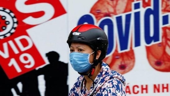 A woman wearing a protective mask drives past a banner promoting prevention against Covid-19 in Hanoi, Vietnam. (Reuters file photo) A woman wearing a protective mask drives past a banner promoting prevention against Covid-19 in Hanoi, Vietnam. (Reuters file photo)