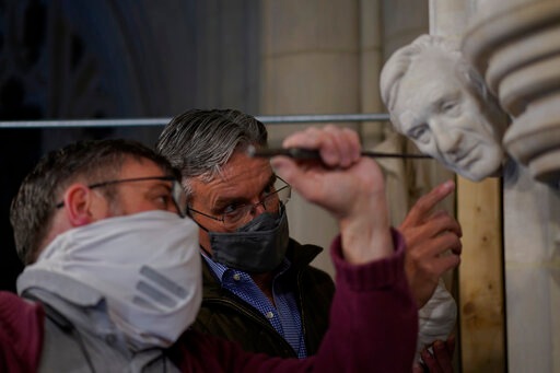 Artist Chas Fagan, right, works to fine tune his sculpture of Holocaust survivor and Nobel Peace Prize winning author Elie Wiesel with stone carver Sean Callahan in the Human Rights Porch of the Washington National Cathedral, Friday, April 16, 2021. Fagan, who created all the sculptures in the Human Rights Porch, worked off photos and videos provided by Wiesel’s family to fashion a clay sculpture of Wiesel's head that Callahan and head stonemason Joe Alonso used to make a plaster model. Then Callahan, using specialized calibration equipment, painstakingly carved the image into a small slab of rock that has been sticking out of the wall for years awaiting a fourth face. (AP) Artist Chas Fagan, right, works to fine tune his sculpture of Holocaust survivor and Nobel Peace Prize winning author Elie Wiesel with stone carver Sean Callahan in the Human Rights Porch of the Washington National Cathedral, Friday, April 16, 2021. Fagan, who created all the sculptures in the Human Rights Porch, worked off photos and videos provided by Wiesel’s family to fashion a clay sculpture of Wiesel's head that Callahan and head stonemason Joe Alonso used to make a plaster model. Then Callahan, using specialized calibration equipment, painstakingly carved the image into a small slab of rock that has been sticking out of the wall for years awaiting a fourth face. (AP)