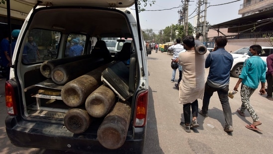 People waiting for oxygen cylinder refills outside a filling plant in Naraina, New Delhi on April 27. With the procurement of more cryogenic tankers to transport liquid oxygen from the central pool, and the creation of more plants in the city to create medical oxygen from ambient air, the capital’s oxygen situation is likely to stabilise slightly over the week, according to government officials and calculations by HT.(Sanjeev Verma / HT Photo)