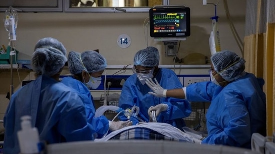 Medical workers tend to a patient suffering from the coronavirus disease (Covid-19), inside the ICU ward at Holy Family Hospital in New Delhi, India.(Reuters)