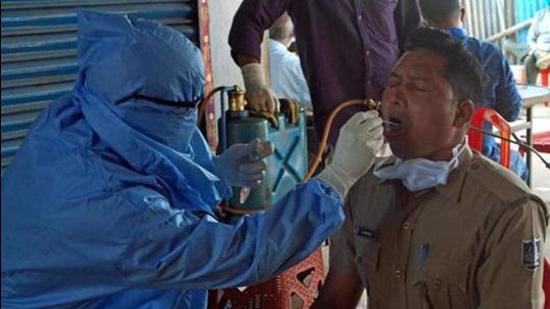 Odisha: A health worker collects swab sample of a police personnel for Covid-19 test. (ANI) Odisha: A health worker collects swab sample of a police personnel for Covid-19 test. (ANI)