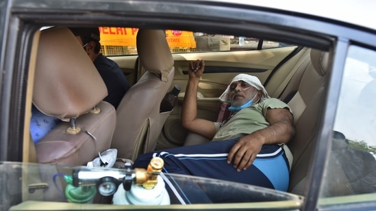A Covid-19 patient on oxygen support waiting in a car outside a hospital in New Delhi on April 26. But while patients already admitted to hospitals may be getting oxygen now, a major problem still persists for new patients who are in need of urgent care. Officials in several hospitals told HT that new admissions have been halted for now.(Raj K Raj / HT Photo)