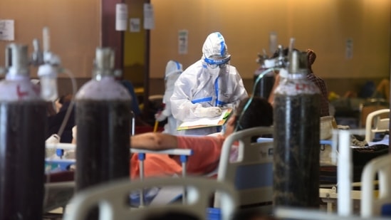 Medical staff in PPE attending to a person in the temporary Covid-19 care centre attached to LNJP Hospital in Delhi.