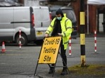 A NHS 'test and trace' worker moves a sign at a drive through/walk up Covid-19 testing facility in Moston, geater Manchester. (AFP) A NHS 'test and trace' worker moves a sign at a drive through/walk up Covid-19 testing facility in Moston, geater Manchester. (AFP)