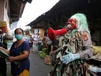 An Indonesian police officer wearing a Balinese traditional mask called 'celuluk', performs during a campaign calling for people to wear masks. An Indonesian police officer wearing a Balinese traditional mask called 'celuluk', performs during a campaign calling for people to wear masks.