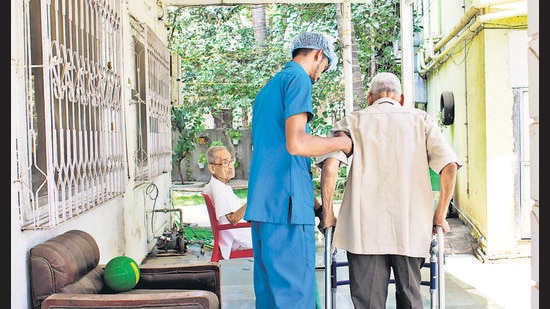 An Aaji Care attendant helps a senior out on a walk.