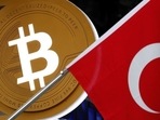 A bitcoin logo is seen next to Turkish flag at a cryptocurrency exchange shop in Istanbul, Turkey.