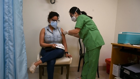 A medical worker inoculates a woman with a dose of the Covishield, AstraZeneca-Oxford's Covid-19 vaccine, at Max hospital in New Delhi on May 1. Some private hospital chains commenced the Covid-19 immunisation drive for the 18-44 age group at limited centres in the country in the third phase of the nationwide Covid-19 vaccination drive.(Tauseef Mustafa / AFP)