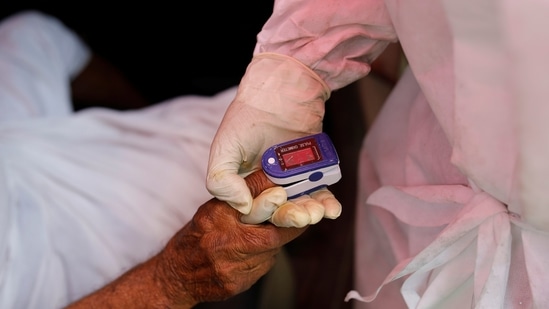 A volunteer uses an oximeter to check the oxygen level of a man before providing oxygen support outside a Gurudwara in Ghaziabad. (REUTERS) A volunteer uses an oximeter to check the oxygen level of a man before providing oxygen support outside a Gurudwara in Ghaziabad.