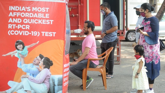 A health worker collects swab samples of citizens for Covid-19 tests at NESCO Jumbo Covid-19 Centre in Mumbai on April 30. As the second wave has picked up steam, India has added about 7.7 million cases since the end of February, according to a Reuters tally. In contrast, it took India nearly six months to add the previous 7.7 million cases.(Vijay Bate / HT Photo)