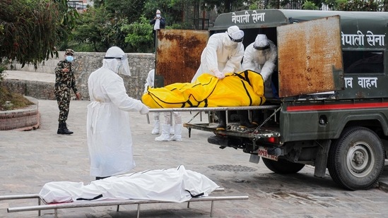 Nepalese army officials wearing protective gear carry the bodies of victims who died of the Covid-19 coronavirus at an electric crematorium in Kathmandu. (AFP) Nepalese army officials wearing protective gear carry the bodies of victims who died of the Covid-19 coronavirus at an electric crematorium in Kathmandu. (AFP)