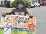 West Bengal Election Results 2021: A TMC supporter holds a placard outside West Bengal chief minister Mamata Banerjee's residence during the counting of votes in Kolkata on Sunday(PTI) West Bengal Election Results 2021: A TMC supporter holds a placard outside West Bengal chief minister Mamata Banerjee's residence during the counting of votes in Kolkata on Sunday(PTI)
