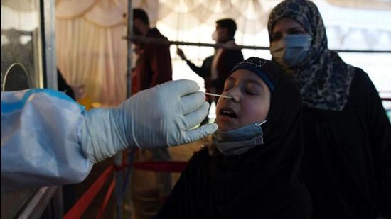 SRINAGAR,INDIA-APRIL17: A health worker takes a nasal swab sample of a girl to test for COVID-19 at a test center in Srinagar. SRINAGAR,INDIA-APRIL17: A health worker takes a nasal swab sample of a girl to test for COVID-19 at a test center in Srinagar.