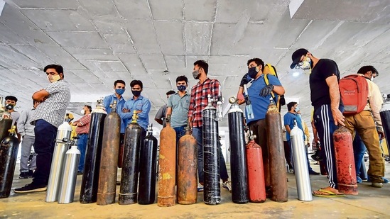 People wait to refill oxygen cylinders at a gurudwara in NCR.(PTI)