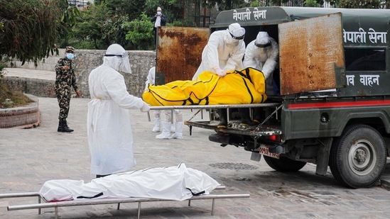 Nepalese army officials wearing protective gear carry the bodies of victims who died of the Covid-19 coronavirus at an electric crematorium in Kathmandu. (AFP) Nepalese army officials wearing protective gear carry the bodies of victims who died of the Covid-19 coronavirus at an electric crematorium in Kathmandu. (AFP)