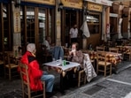 People sit at a restaurant's terrace on Monastiraki square in Athens on May 3, 2021, as restaurants and cafes in Greece open after six months of lockdown due to the Covid-19 pandemic.(AFP) People sit at a restaurant's terrace on Monastiraki square in Athens on May 3, 2021, as restaurants and cafes in Greece open after six months of lockdown due to the Covid-19 pandemic.(AFP)