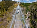 A woman walks across a narrow footbridge suspended across a river canyon, which claims to be the world's longest pedestrian bridge, in Arouca, northern Portugal, Sunday, May 2, 2021. The Arouca Bridge inaugurated Sunday, offers a half-kilometer (almost 1,700-foot) walk across its span, some 175 meters (574 feet) above the River Paiva.(AP) A woman walks across a narrow footbridge suspended across a river canyon, which claims to be the world's longest pedestrian bridge, in Arouca, northern Portugal, Sunday, May 2, 2021. The Arouca Bridge inaugurated Sunday, offers a half-kilometer (almost 1,700-foot) walk across its span, some 175 meters (574 feet) above the River Paiva.(AP)
