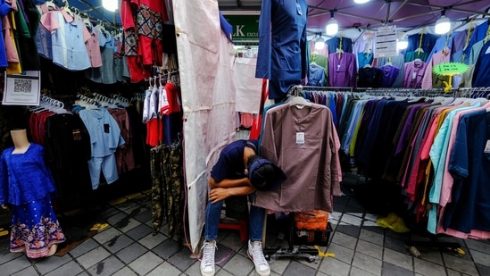 A vendor sits outside a stall in a deserted 'Ramadan market' set up by the district government in Kuala Lumpur, Malaysia.(Bloomberg) A vendor sits outside a stall in a deserted 'Ramadan market' set up by the district government in Kuala Lumpur, Malaysia.(Bloomberg)