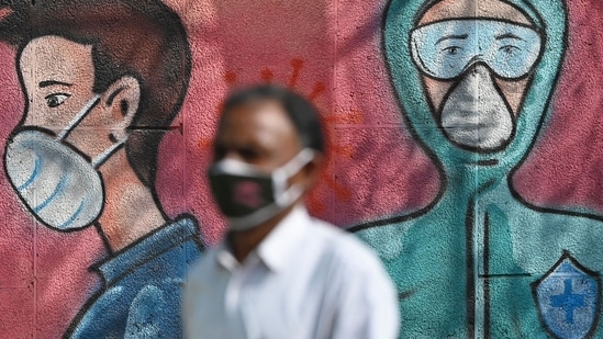 File photo: A pedestrian walks past a wall mural depicting frontline Covid-19 coronavirus warriors wearing face masks along a road. (AFP) File photo: A pedestrian walks past a wall mural depicting frontline Covid-19 coronavirus warriors wearing face masks along a road. (AFP)