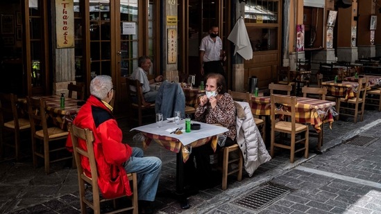 People sit at a restaurant's terrace on Monastiraki square in Athens on May 3, 2021, as restaurants and cafes in Greece open after six months of lockdown due to the Covid-19 pandemic. (AFP) People sit at a restaurant's terrace on Monastiraki square in Athens on May 3, 2021, as restaurants and cafes in Greece open after six months of lockdown due to the Covid-19 pandemic. (AFP)