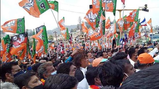 Tamil Nadu, March 31 (ANI): BJP supporters carry party flag during the roadshow of Defence Minister Rajnath Singh in Udhagmandalam ahead of the assembly elections, on Wednesday. (ANI Photo) (ANI)