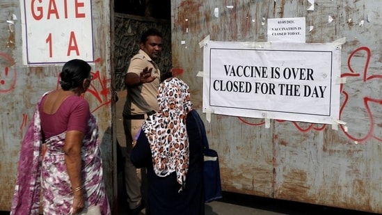 A policeman asks people who came to receive a dose of a coronavirus disease (COVID-19) vaccine to leave as they stand outside the gate of a vaccination centre which was closed due to unavailability of the supply of COVID-19 vaccine, in Mumbai, India, May 3, 2021. (REUTERS)