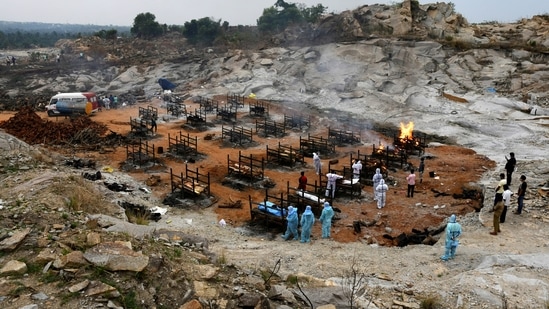 Volunteers and relatives prepare to cremate the bodies of people who died due to coronavirus disease (Covid-19), at a crematorium ground in Giddenahalli village on the outskirts of Bengaluru, India, on May 2, 2021. (Reuters)