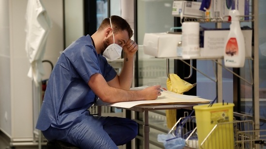 A healthcare worker looks at a Covid-19 patient's medical notes in the Intensive Care Unit (ICU) at the Centre Cardiologique du Nord private hospital in Saint-Denis, near Paris, amid the coronavirus disease pandemic in France. (Reuters)