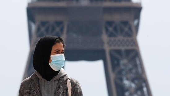 A woman, wearing a hijab and a protective face mask, walks at Trocadero square near the Eiffel Tower in Paris, France. (Reuters)