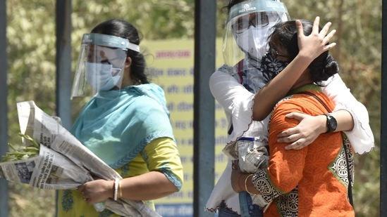 Relatives of a Covid-19 victim during the cremation, at a crematorium, in Sector 94, in Noida. ( Sunil Ghosh / HT Photo)