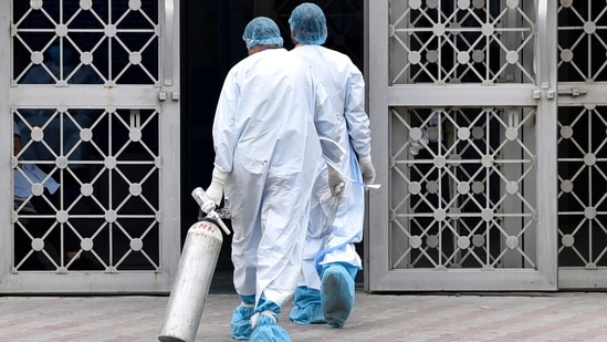 Health workers carrying an oxygen cylinder at Delhi’s LNJP hospital on Tuesday. (Photo by Sanjeev Verma/ Hindustan Times) (Sanjeev Verma/HT PHOTO) Health workers carrying an oxygen cylinder at Delhi’s LNJP hospital on Tuesday. (Photo by Sanjeev Verma/ Hindustan Times) (Sanjeev Verma/HT PHOTO)