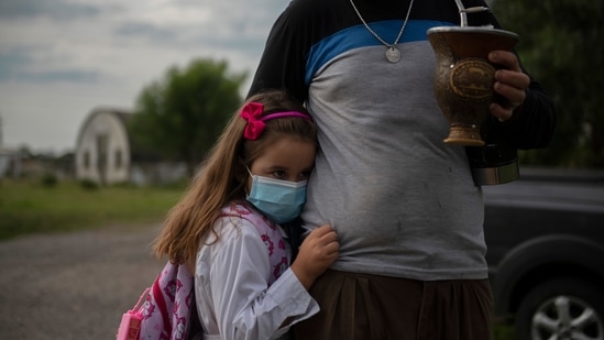 A girl embraces her father before entering school for the first time since it was closed due to the Covid-19 pandemic in Migues.(AP)