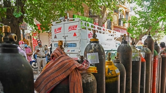 People wait to refill their medical oxygen cylinders for Covid-19 patients in Delhi on May 4, 2021, 