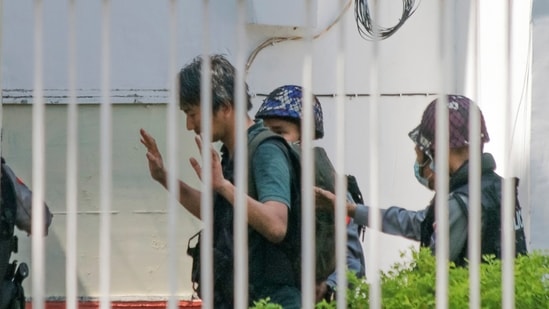 In this Feb. 26, 2021, photo, Japanese journalist Yuki Kitazumi raises his hands as he is escorted by police upon arrival at the Myaynigone police station in Sanchaung township in Yangon, Myanmar. (AP Photo) In this Feb. 26, 2021, photo, Japanese journalist Yuki Kitazumi raises his hands as he is escorted by police upon arrival at the Myaynigone police station in Sanchaung township in Yangon, Myanmar. (AP Photo)