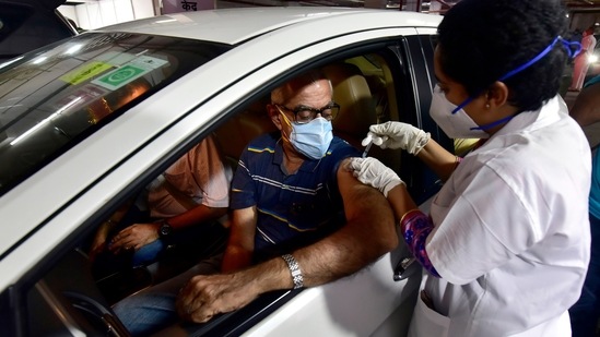 A man is inoculated at a drive-in-car vaccination centre started by BMC at Kohinoor parking in Dadar, Mumbai on May 4. According to government data, vaccinations have also slowed down in Maharashtra. Because of a shortage of vaccines, states such as Bihar, Madhya Pradesh, Uttarakhand and Tamil Nadu are unclear on when they can start the vaccination for those below 45 years of age.(Anshuman Poyrekar / HT Photo)