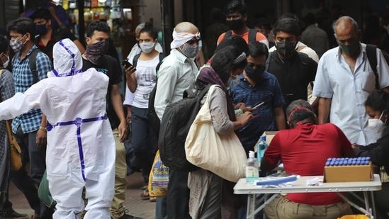 Health worker directs arriving passengers towards Covid-19 testing counter outside a train station in Bengaluru.(AP file photo) Health worker directs arriving passengers towards Covid-19 testing counter outside a train station in Bengaluru.(AP file photo)