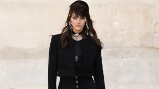 With a buttoned peplum that sculpts the waist, Virginie Viard creates a new feminine interpretation of the tweed jacket for the CHANEL Cruise 2021/22 collection, worn with fluid jodhpurs and patent glove booties for a monochrome allure. (Chanel website) With a buttoned peplum that sculpts the waist, Virginie Viard creates a new feminine interpretation of the tweed jacket for the CHANEL Cruise 2021/22 collection, worn with fluid jodhpurs and patent glove booties for a monochrome allure. (Chanel website)