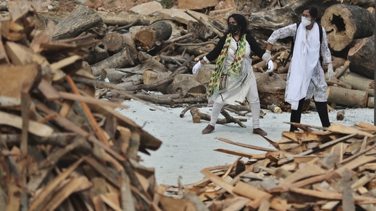 A woman pulls away her crying relative as she reacts to the burning funeral pyre of their family member who died of Covid-19, at an open crematorium set up at a granite quarry on the outskirts of Bengaluru on May 5. Medical experts say the actual numbers of dead and infected in India could be five to 10 times the official tallies, Reuters reported. (Aijaz Rahi / AP) A woman pulls away her crying relative as she reacts to the burning funeral pyre of their family member who died of Covid-19, at an open crematorium set up at a granite quarry on the outskirts of Bengaluru on May 5. Medical experts say the actual numbers of dead and infected in India could be five to 10 times the official tallies, Reuters reported. (Aijaz Rahi / AP)