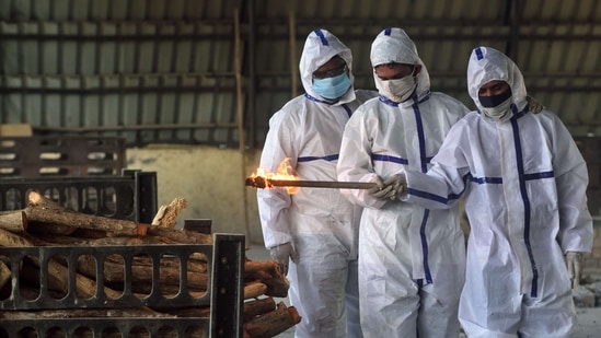 Helped by family members wearing personal protective equipment (PPE) suits, a person lights the pyre while cremating the body of the relative who succumbed to Covid-19 at Vasai crematorium, Mumbai on May 4. Daily testing in India has also fallen sharply to 1.5 million, the Indian Council of Medical Research (ICMR) said on May 6. It hit a peak of 1.95 million on May 1. (Satish Bate / HT Photo) Helped by family members wearing personal protective equipment (PPE) suits, a person lights the pyre while cremating the body of the relative who succumbed to Covid-19 at Vasai crematorium, Mumbai on May 4. Daily testing in India has also fallen sharply to 1.5 million, the Indian Council of Medical Research (ICMR) said on May 6. It hit a peak of 1.95 million on May 1. (Satish Bate / HT Photo)
