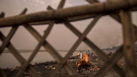 Funeral pyres burning amid mass cremations of Covid-19 fatalities and the recently deceased on the banks of the Yamuna river in Garh on May 4. Some experts believe a temporary shutdown is essential to stem India's outbreak, but others say a complete national lockdown isn't possible and would be disastrous for the poor, who have already suffered the most during the outbreak. (Anindito Mukherjee / Bloomberg) Funeral pyres burning amid mass cremations of Covid-19 fatalities and the recently deceased on the banks of the Yamuna river in Garh on May 4. Some experts believe a temporary shutdown is essential to stem India's outbreak, but others say a complete national lockdown isn't possible and would be disastrous for the poor, who have already suffered the most during the outbreak. (Anindito Mukherjee / Bloomberg)