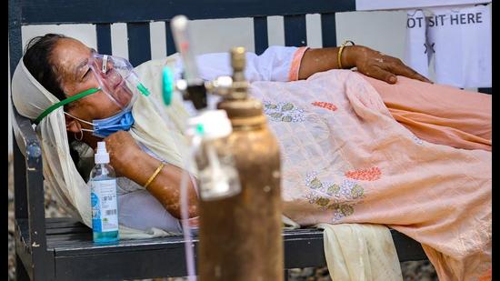 COVID patients on oxygen support wait outside a hospital for admission, in Jammu, on Thursday. (PTI) COVID patients on oxygen support wait outside a hospital for admission, in Jammu, on Thursday. (PTI)