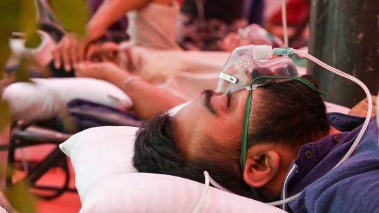 A Covid-19 coronavirus patient breathes with the help of oxygen provided by a Gurdwara, a place of worship for Sikhs, under a tent installed along the roadside in Ghaziabad. (AFP)