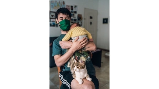 NEW LIFE: Analia Cid (@analia.cid), 31, of Argentina, submitted an image of her partner Agustín, 31, their cat and his newborn nephew and godson Milo. “Since he was born, Agustín has lived with a heart condition that puts him in the high-risk group for Covid-19. During the first lockdown in Argentina, we were very careful; anything could represent a danger to his health. But on his birthday, in October, his sister and Milo visited us,” Cid says. “I wanted to express the tenderness and vulnerability of the moment. Our societies tend to erase ways of living healthier masculinities from the public view and I think that as photographers, it is our job to show that this is possible. I was also thinking on how much I love these three.”(Analia Cid)