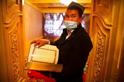 Tursunjan Mamat holds a copy of the Quran in the Arabic and Uyghur languages during a government organized visit for foreign journalists to his home in Aksu in western China's Xinjiang Uyghur Autonomous Region on April 20, 2021. (AP) Tursunjan Mamat holds a copy of the Quran in the Arabic and Uyghur languages during a government organized visit for foreign journalists to his home in Aksu in western China's Xinjiang Uyghur Autonomous Region on April 20, 2021. (AP)